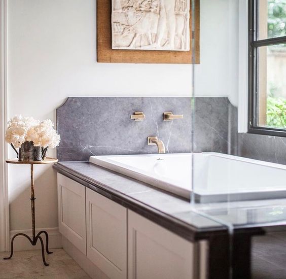 grey marble and gilded faucets make this bathtub space very sophisticated and personalized