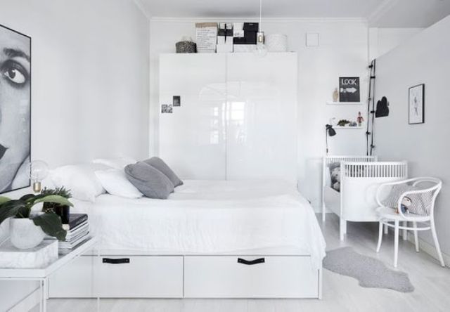 a monochrome Scnadinavian bedroom with minimalist furniture and a crib in the corner, a chair and lights are a must there