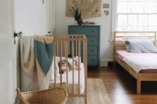22 a natural master bedroom with a vintage feel and a baby’s nook with a crib, a basket and shelves in the same style