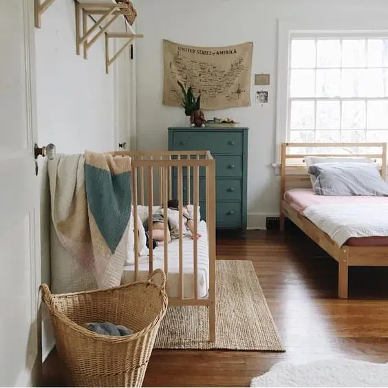 a natural master bedroom with a vintage feel and a baby's nook with a crib, a basket and shelves in the same style