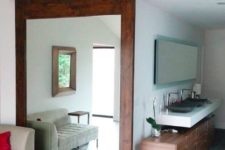 22 a rich-colored large barn door features a big mirror that doubles the living room space