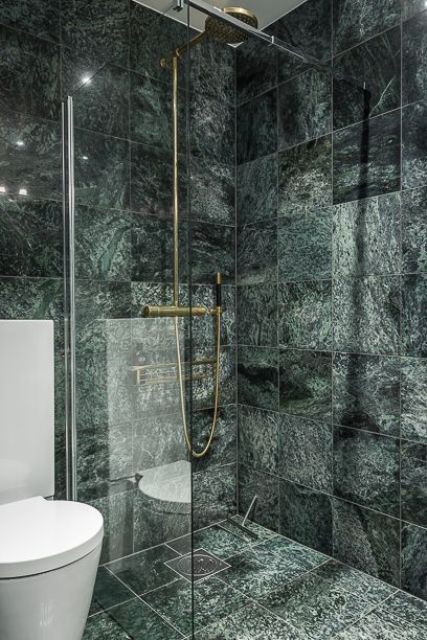 contemporary bathroom with brass fixtures and dark green marble tiles for a catchy modern look