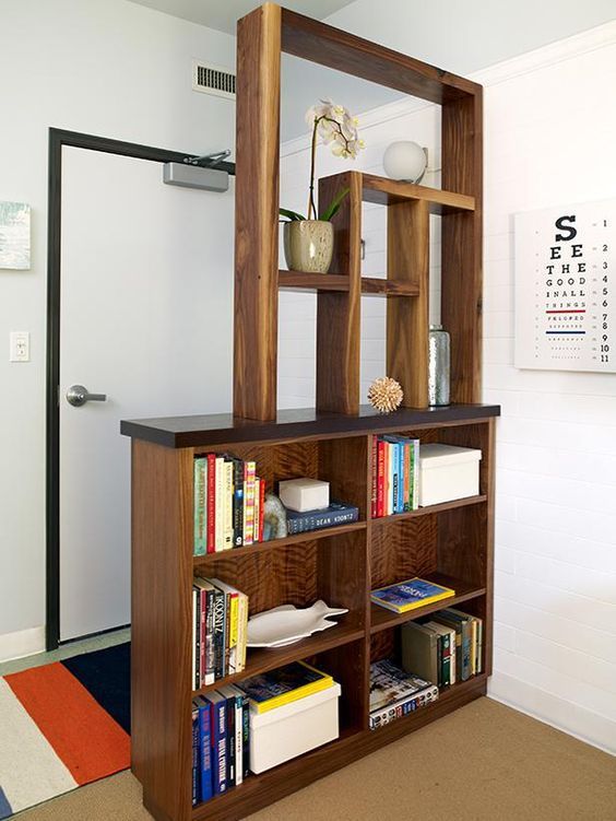 create an entryway if there's none with a large wooden shelving unit with several box shelves