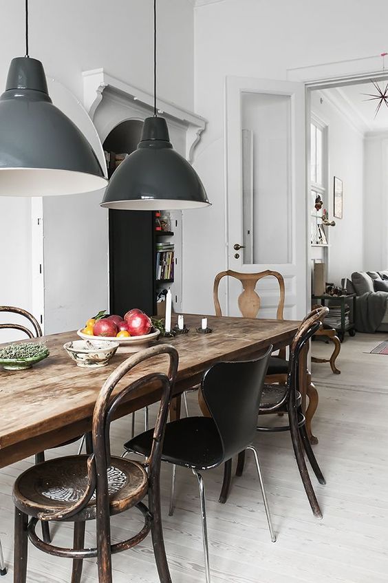 a rustic antique table and a mix of rustic and modern chairs of metal, wood and leather