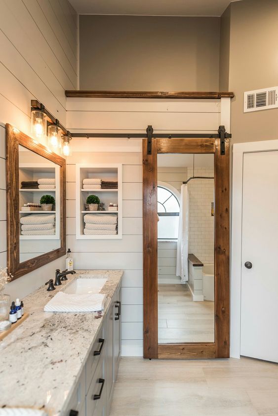 a sliding barn door with a mirror insert is a great idea for the bathroom as the mirror is a must for such a space