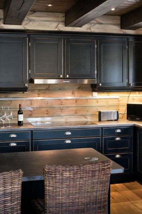 vintage black cabinets, silver handles and a wooden plank backsplash with an additional glass screen for protection