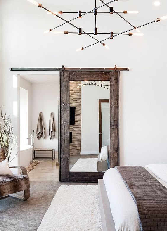 a sliding barn door with a mirror is a chic idea, a combo of modern and rustic things for a modern farmhouse