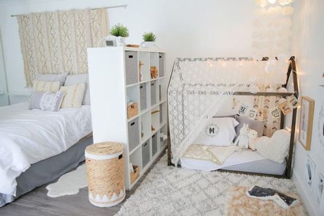 separate a nursery nook in your master bedroom with a comfy white shelving unit inserting some boxes for more privacy
