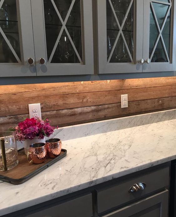 vintage grey cabinets, a marble countertop and a wooden plank backsplash for a less formal look