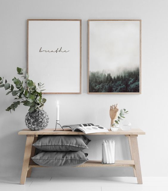 a wooden bench with a shelf for storage and a duo of artworks for a peaceful and calm look