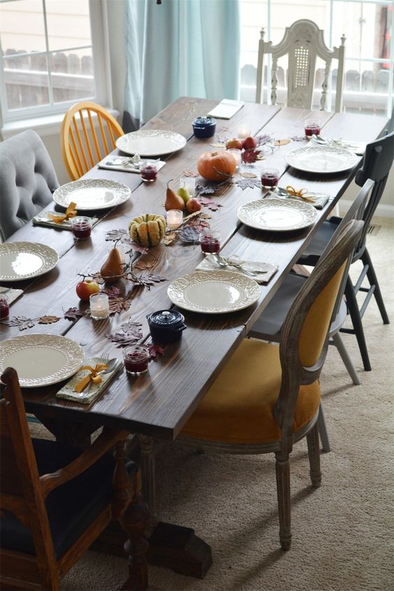 an antique rustic table with a mix of bold chairs in vintage, shabby chic and modern style in various colors