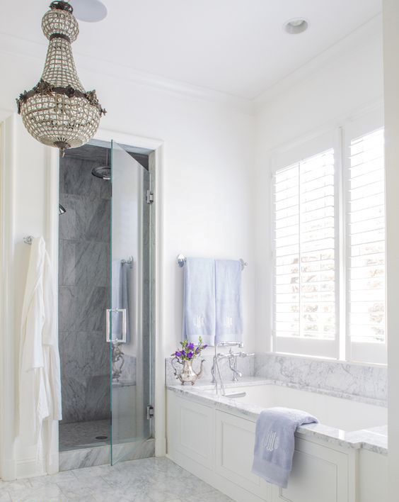 white and grey marble was used to clad the backsplash and the bathtub to add a refined feel