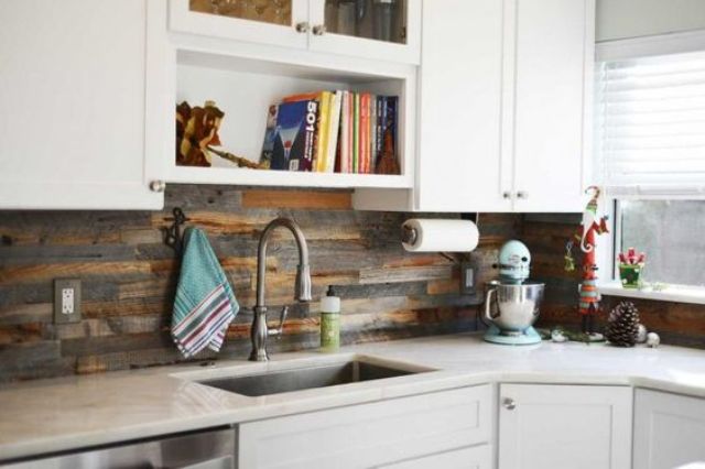 white cabinets are enlivened with a reclaimed wood kitchen backsplash that looks very rustic