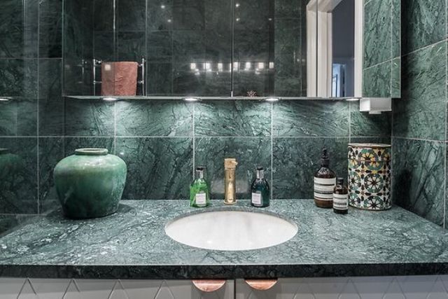 a green marble countertop and matching tiles that cover the walls for a stunning modern look