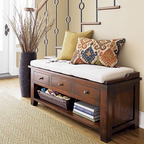 a wooden bench with a cushion, drawers and an open shelf for storage for a rustic space