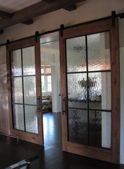 sliding barn doors with rainy glass inserts to make the doors look more subtle and let the light inside