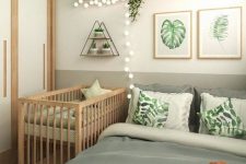 a boho bedroom with a bed and printed bedding, a gallery wall, a shelf with decor, a crib, a wardrobe