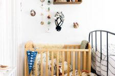 a master bedroom with a little nursery nook, with a crib, a basket, a stool, a crate with toys, some decor and a potted plant
