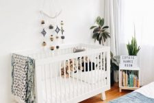 a master bedroom with a small nursery nook, a crib, a mobile, potted plants and a bookshelf is a lovely space