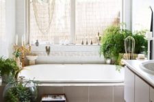 02 a boho chic bathroom with potted greenery, a creative chandelier, candle holders and a faux fur rug