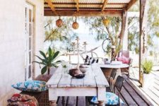 02 a boho colorful porch with a dining zone and a sitting one with lanterns and colorful textiles