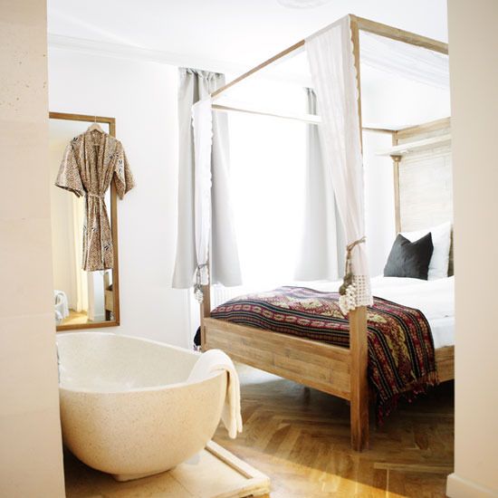 a boho girlish bedroom with a free-standing bathtub next to the bed for adding a luxurious feel