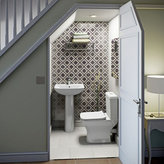 A contemporary powder room done with geometric tiles, a wall mounted shelf for storage