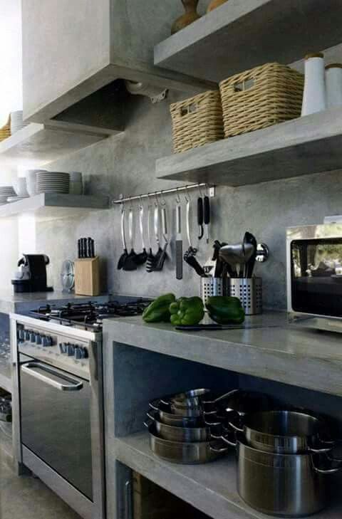 A fully industrial kitchen done in grey concrete, with a backsplash and countertops