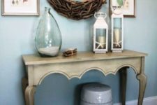 02 a vintage carved console, lanterns with star fish, a bottle with sand, a wood clad mirror