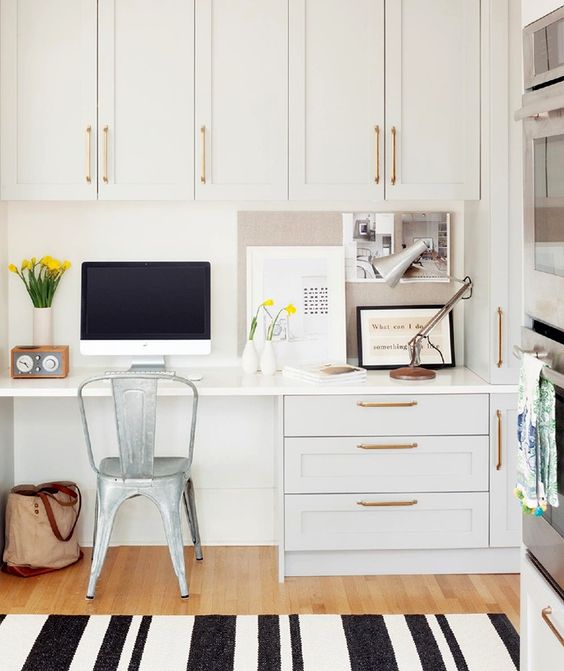 a white glam kitchen with gilded touches and a built-in desk
