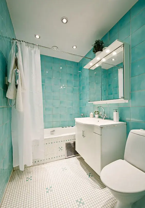 turquoise watercolor tiles cover the whole space and look nice with litte white ones on the floor