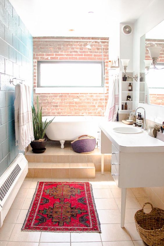 a colorful industrial and boho chic space with a brick wall, baskets and potted succulents