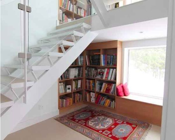 A comfy reading nook with a built in bookcase and a window seat for reading