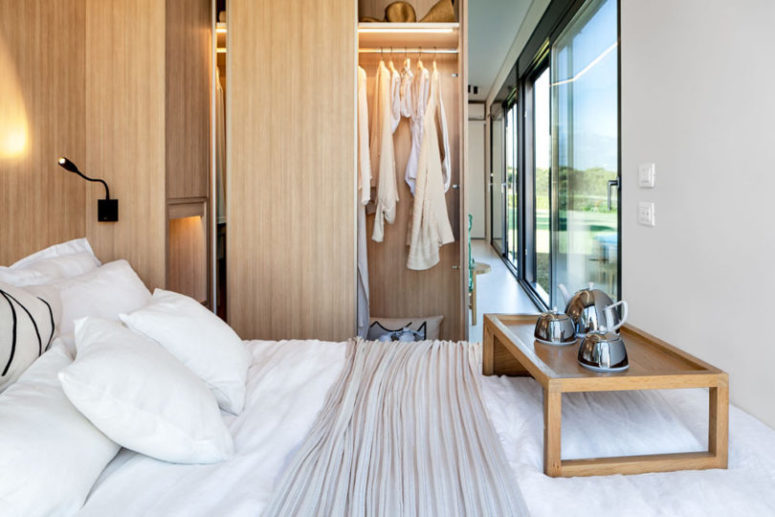 The bedroom space features a comfy bed, some lights and built-in storage compartments