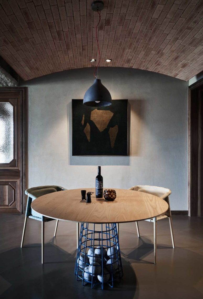 The dining space features artworks and a creative table with rocks inside the ethereal base