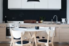 04 a contemporary kitchen with pale wood and white furniture and a chalkboard backsplash and blakc touches for a stylish look