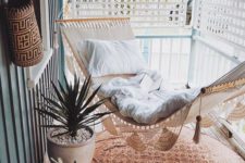 04 a small screened porch with a woven hammock, potted succulents and a boho printed rug