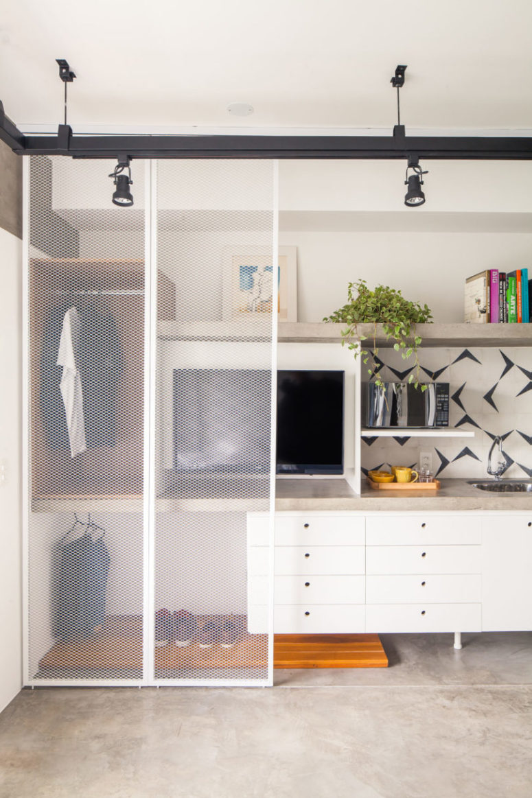 This zone hidden with sliding doors includes a TV, a small closet and a tiny kitchen