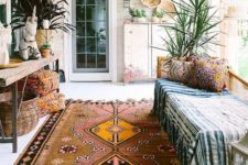 06 a boho porch done with a bench, a wooden console, potted plants, baskets and printed textiles plus a boho rug