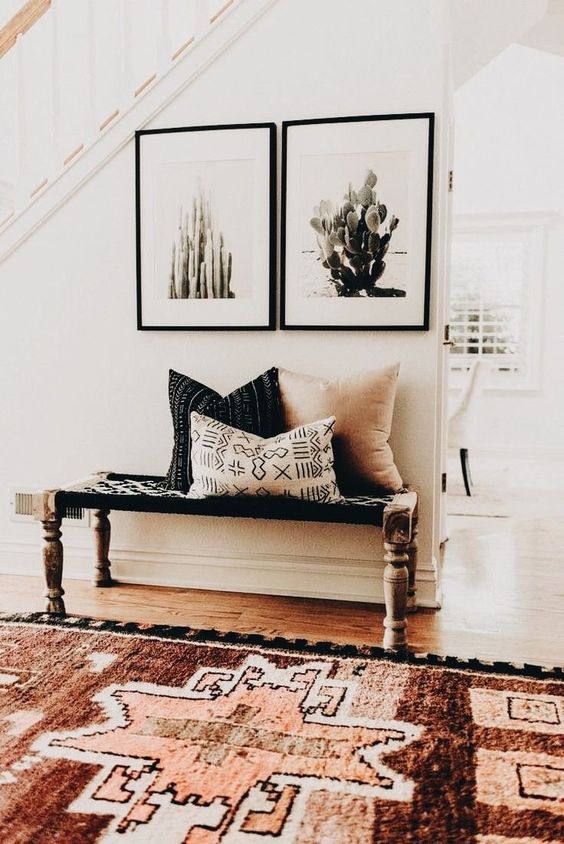 a boho rug, a woven bench and cacti artworks for a desert boho feel