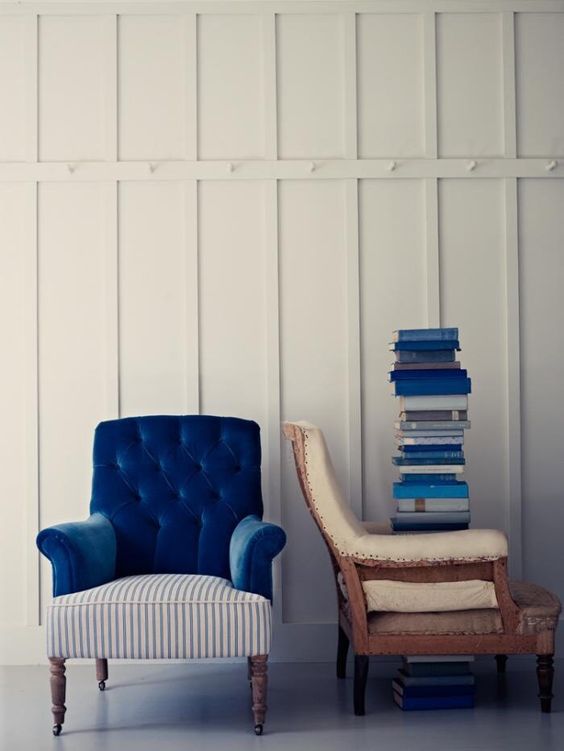 a bold vintage armchair with a navy back and armrests and a striped seat plus wooden legs
