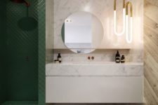 06 a luxurious look is achieved with the use of marble, wood and green tiles that clad the shower space