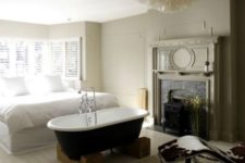 06 a modern meets vintage bedroom with a vintage tub on wooden stands and a vitnage fireplace restored