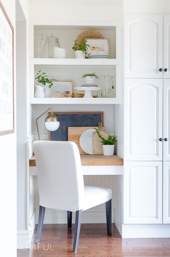 build in a small office nook in your kitchen with shelves and a desk covered with a wooden countertop and a comfy chair
