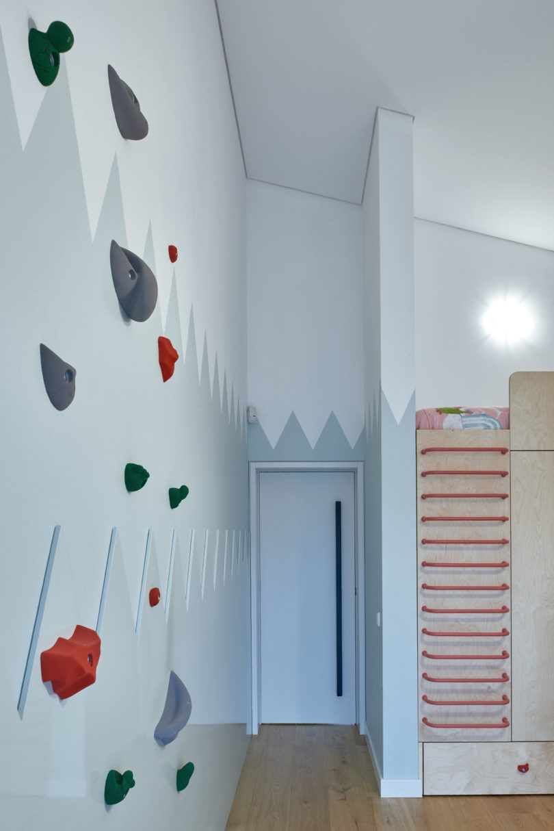 The kid's room is done with a large piece, which includes storage and a bed on top, there's a real climbing wall