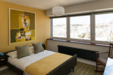 07 The master bedroom is done in mustard shades, with a large window and a cool artwork