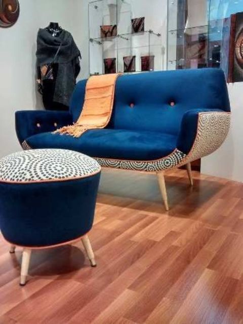 A chic and bold mid century modern chair with a navy top and a printed base and a matching footrest