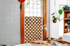 07 a colorful boho bathroom with penny tiles, rich-colored wooden beams, a partly covered window and raw edge wooden items