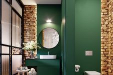 a contemporary bathroom with emerald walls and a space divider and exposed brick for a texture