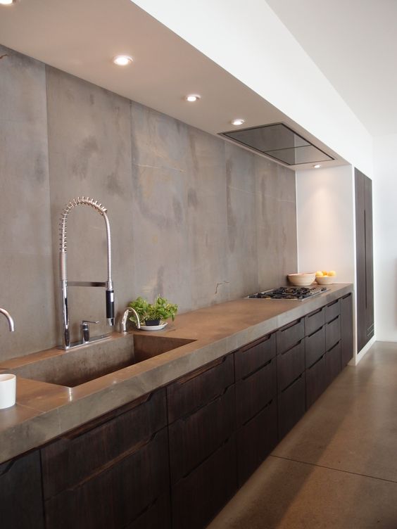 Dark stained wooden cabinets with a concrete backsplash and countertops for a textural and catchy look